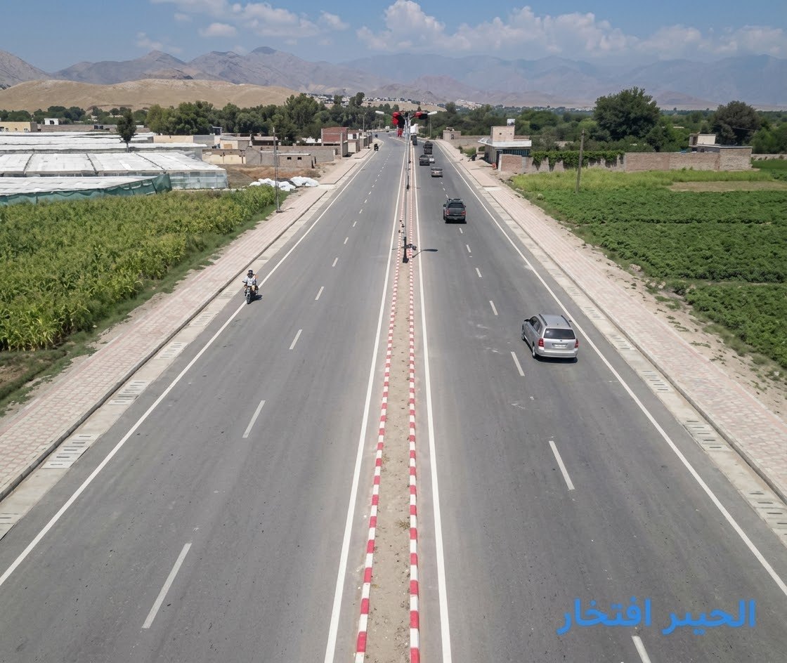 Elevated view along the Mehtarlam Baba Ring Road dual carriageway with kerbed median, paved footways and traffic in both directions